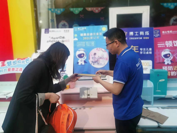 活動現(xiàn)場矯資顧問為客戶講解學習桌賣點